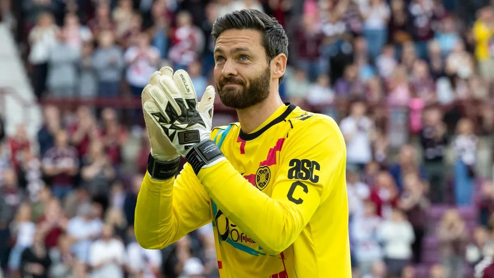 Goalkeeper applauding fans in yellow kit Goalkeeper applauding fans in yellow kit