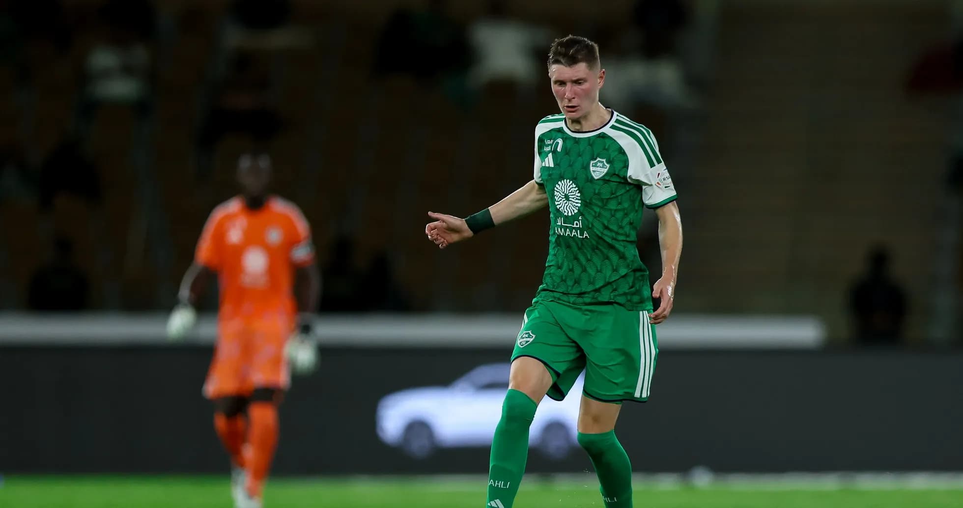 Player in green kit dribbling ball during match Player in green kit dribbling ball during match
