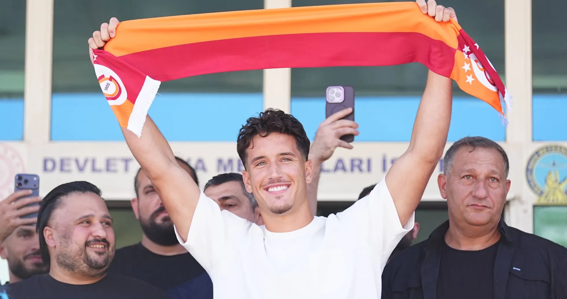 Player holding Galatasaray scarf during announcement event Player holding Galatasaray scarf during announcement event