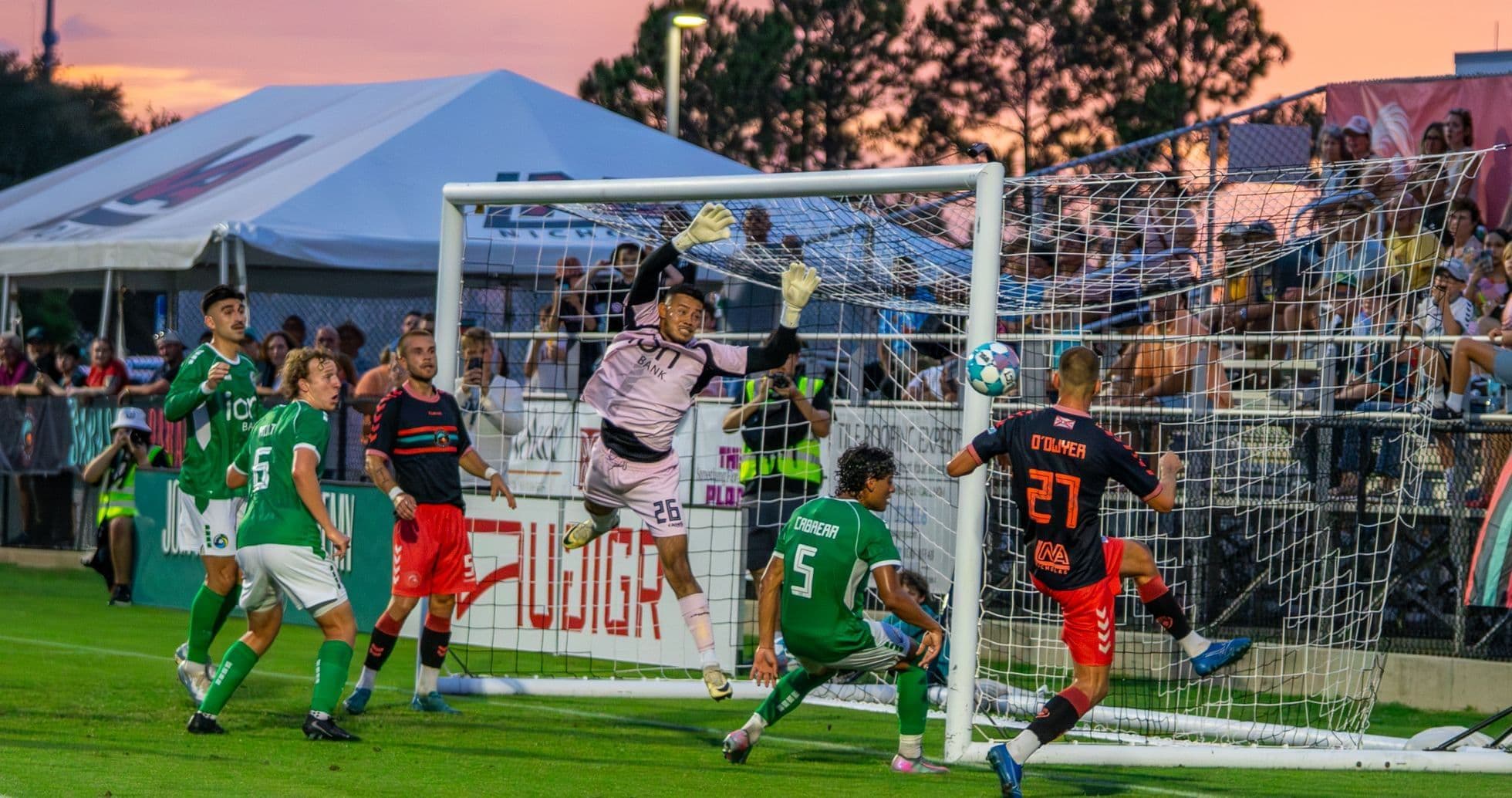 Goalkeeper attempting to save a shot on goal Goalkeeper attempting to save a shot on goal