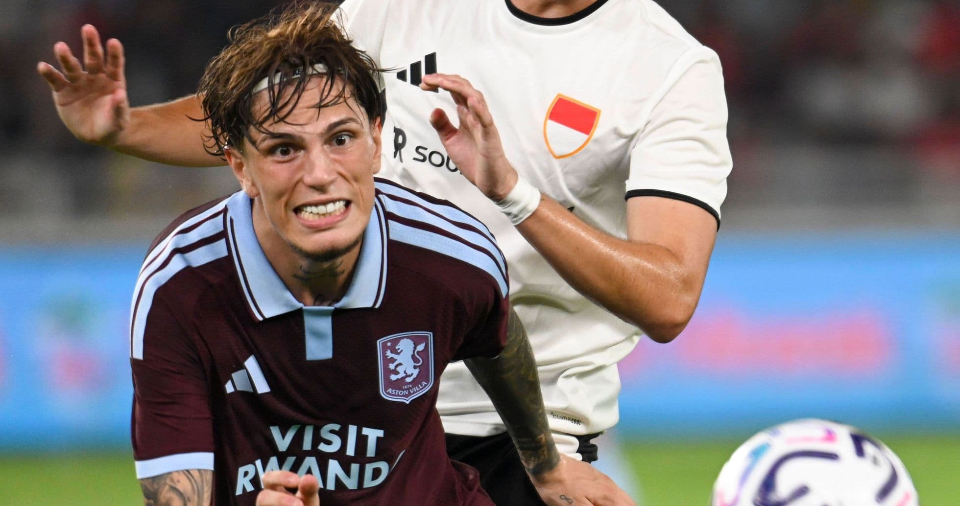 Player in maroon jersey being challenged by opponent Player in maroon jersey being challenged by opponent