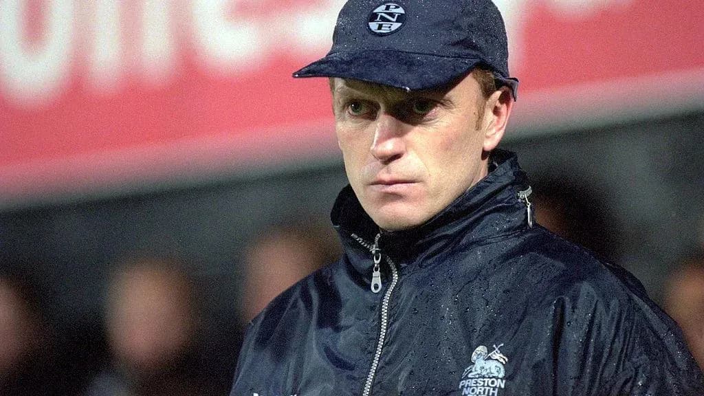 Coach wearing cap during a rainy match Coach wearing cap during a rainy match