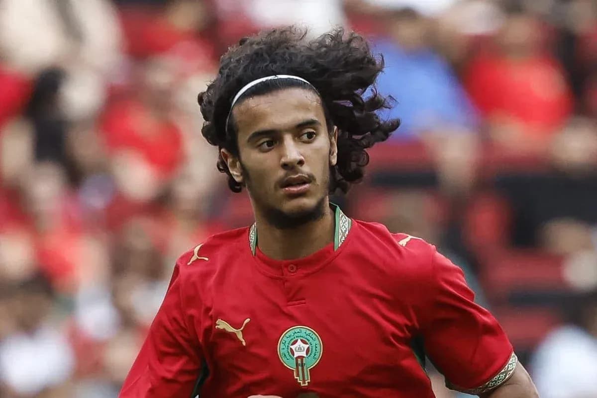 Player in red Morocco jersey running on field Player in red Morocco jersey running on field