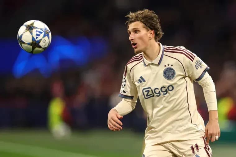 Player in Ajax jersey controlling the ball during match Player in Ajax jersey controlling the ball during match