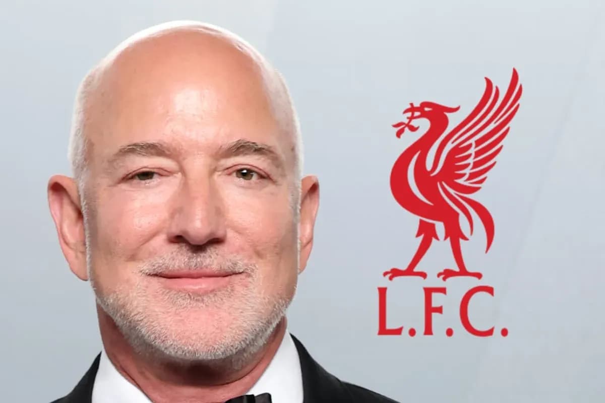 Man in suit with Liverpool FC logo background Man in suit with Liverpool FC logo background