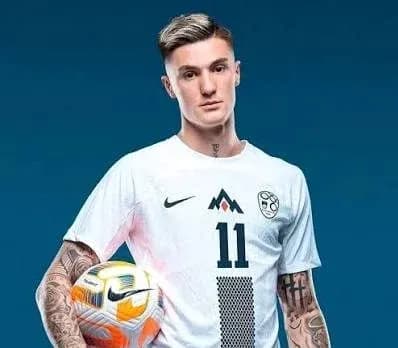 Player posing with a soccer ball in uniform Player posing with a soccer ball in uniform