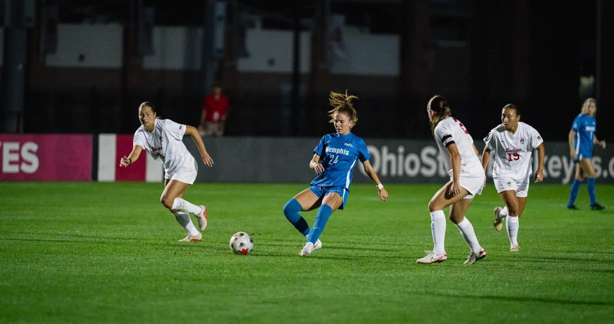 Player in blue dribbling past defenders in soccer match Player in blue dribbling past defenders in soccer match