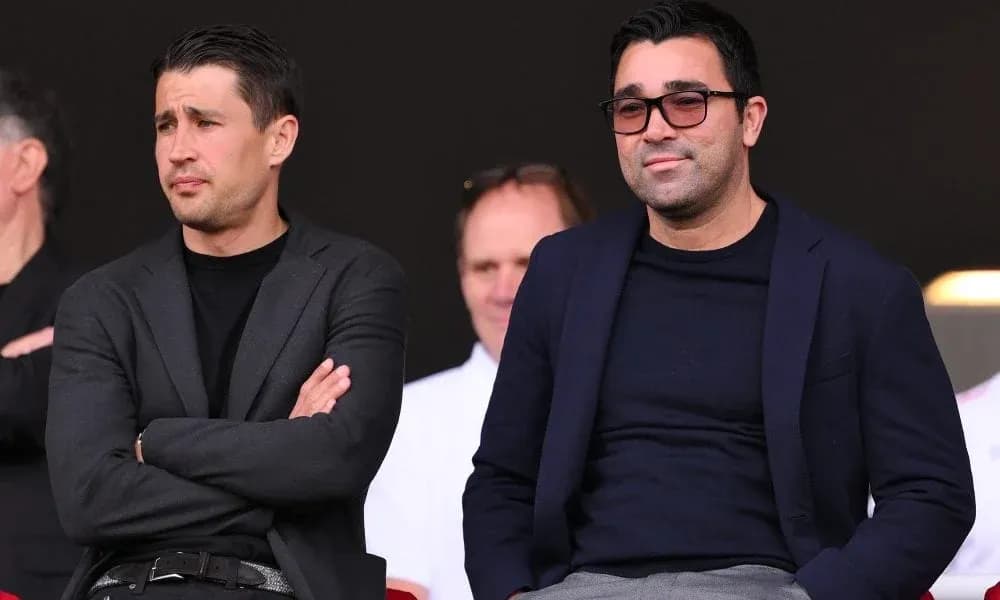 Two men seated in a sports venue viewing event Two men seated in a sports venue viewing event
