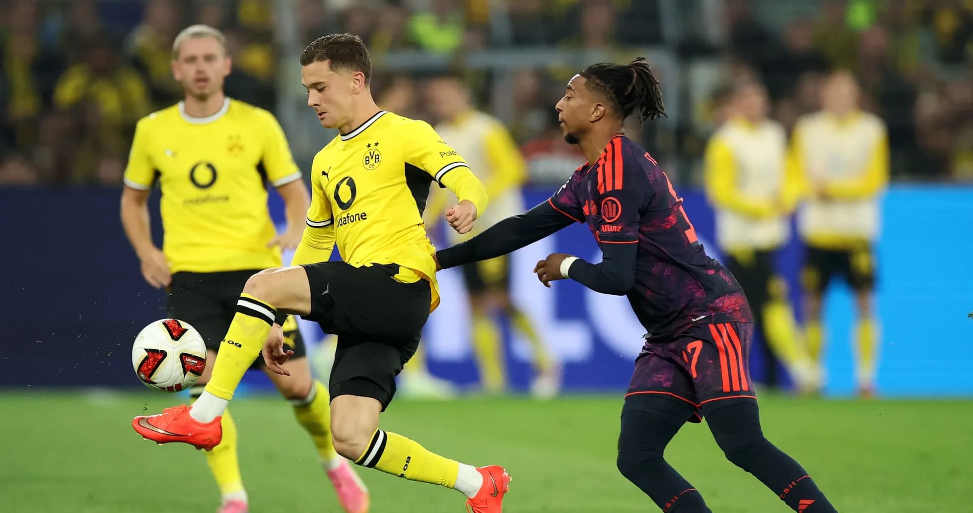 Borussia Dortmund player dribbling past opponent during match Borussia Dortmund player dribbling past opponent during match