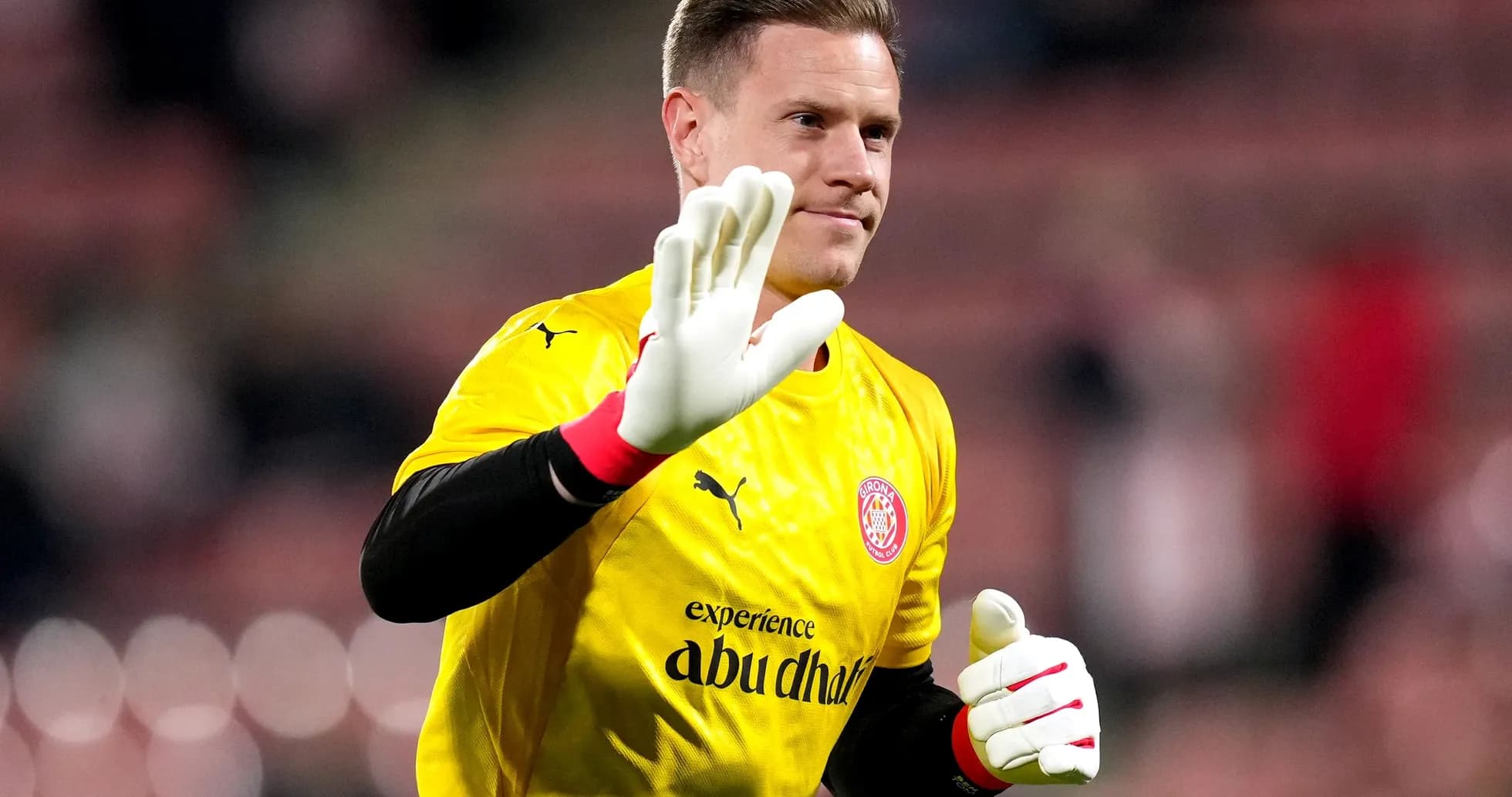 Goalkeeper waving while wearing yellow jersey and gloves Goalkeeper waving while wearing yellow jersey and gloves