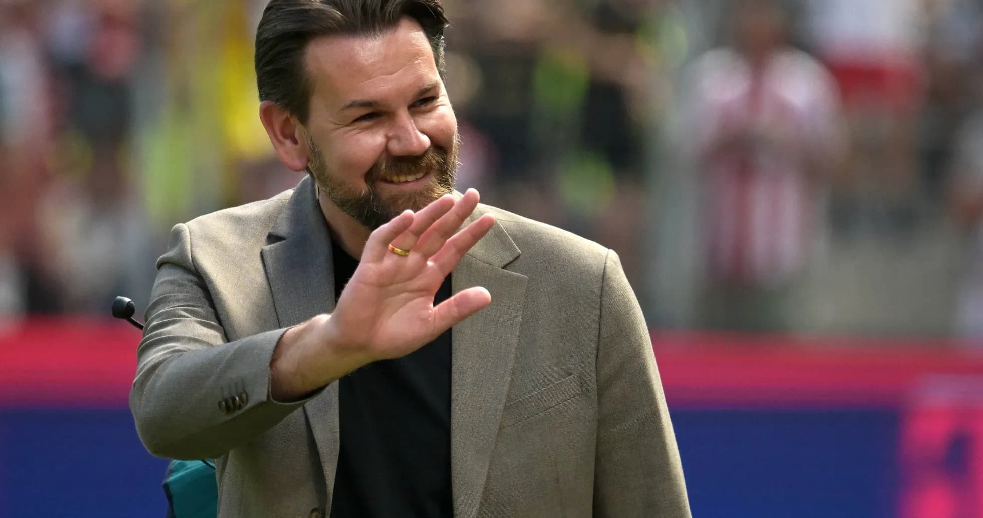 Man waving during a sports event on the field Man waving during a sports event on the field