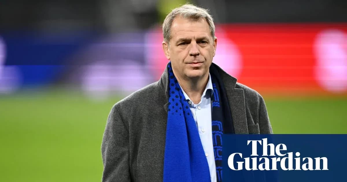 Man in coat and scarf on football pitch Man in coat and scarf on football pitch