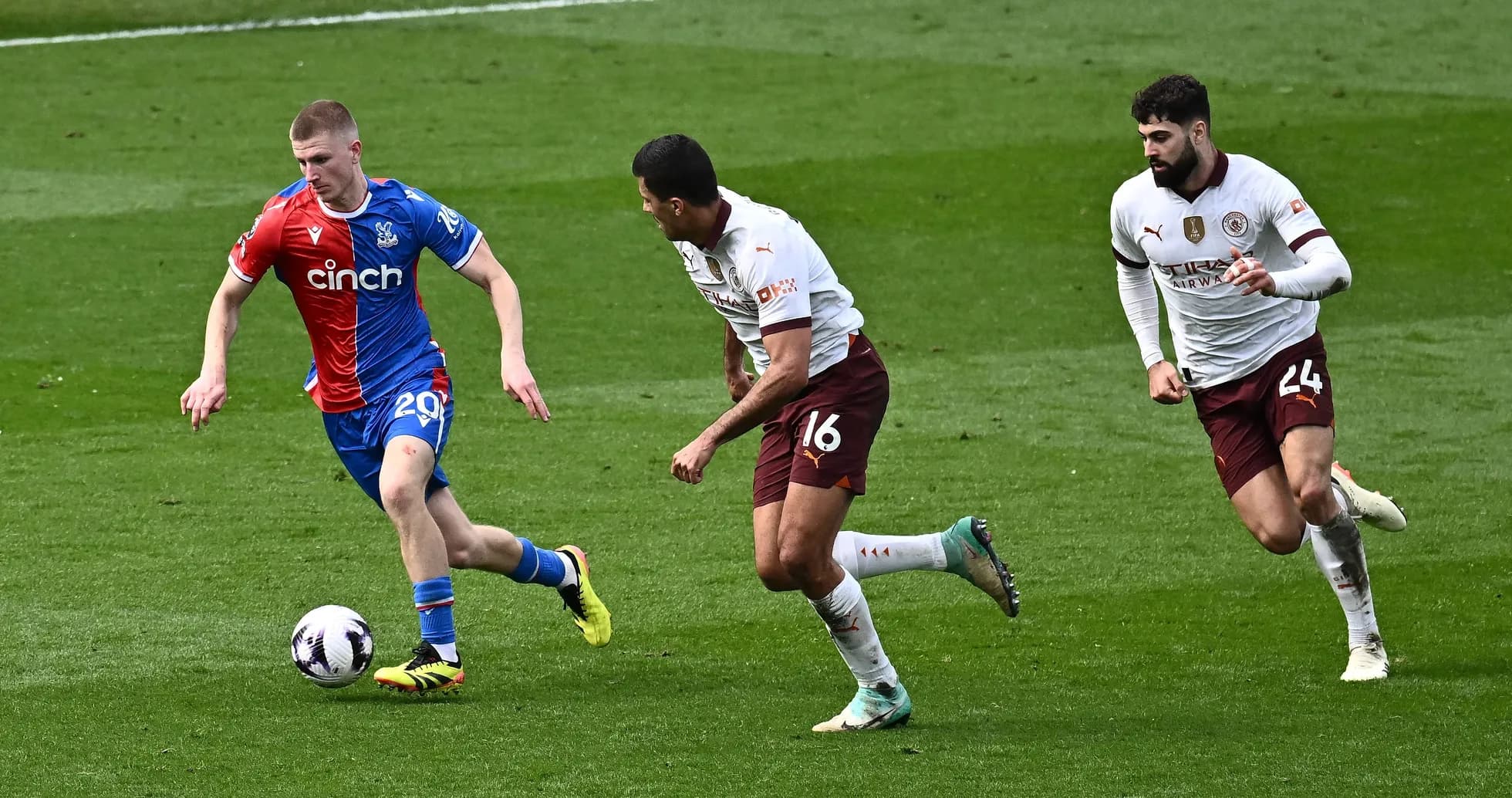 Player in red and blue kit dribbling past two opponents Player in red and blue kit dribbling past two opponents