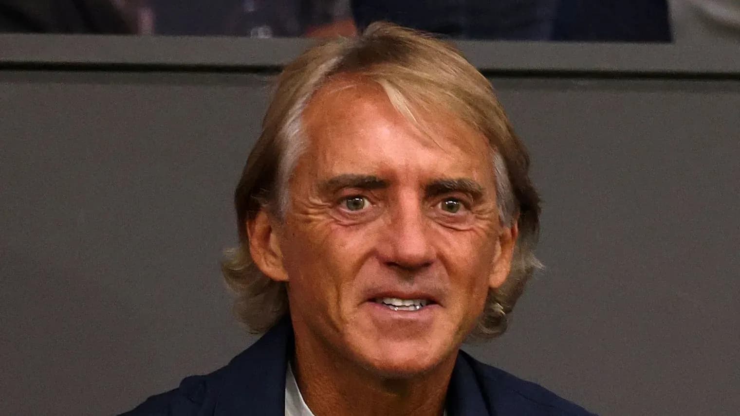 Man with blonde hair smiling at event Man with blonde hair smiling at event
