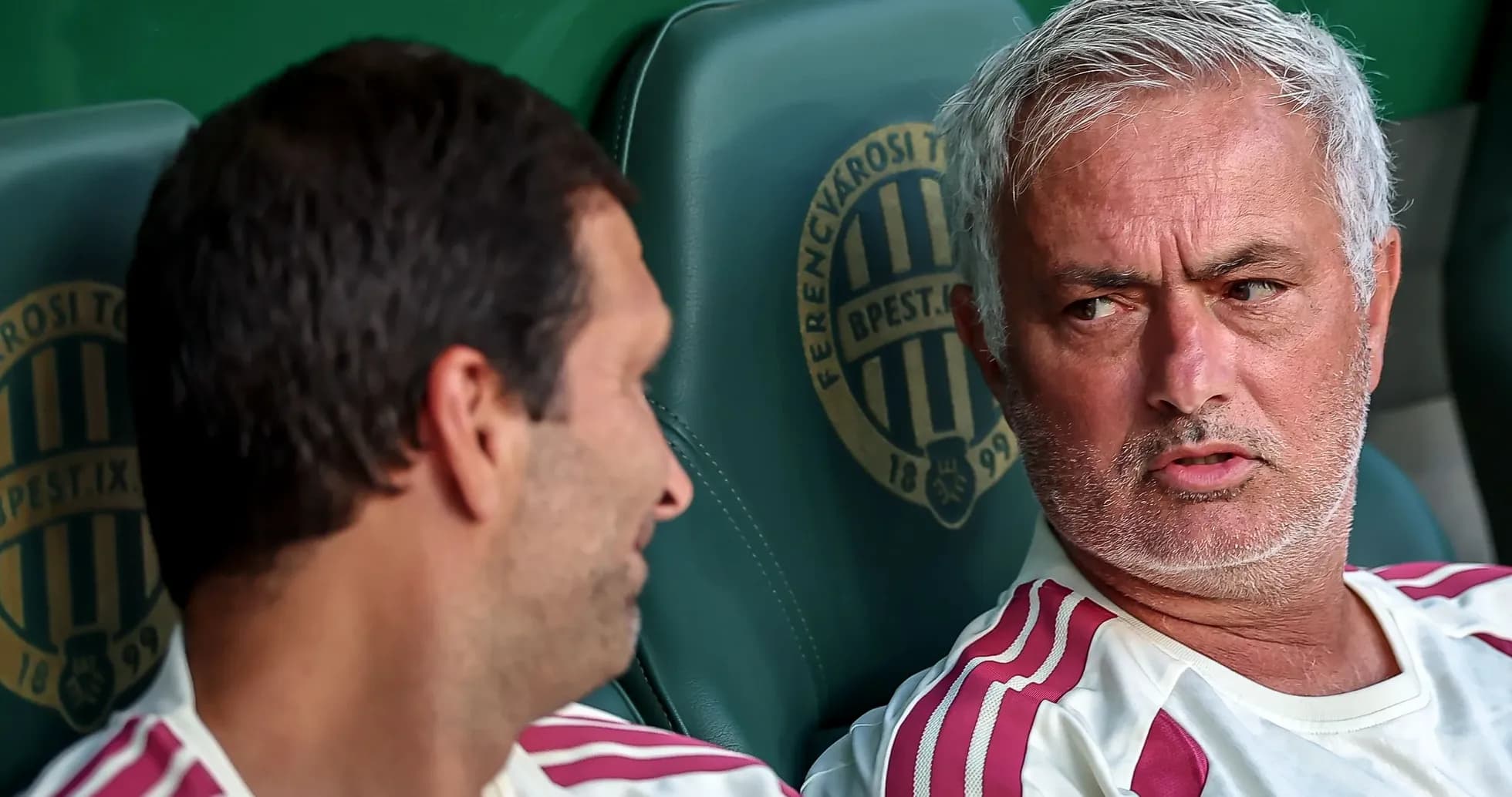 Two coaches seated on the bench during a match Two coaches seated on the bench during a match