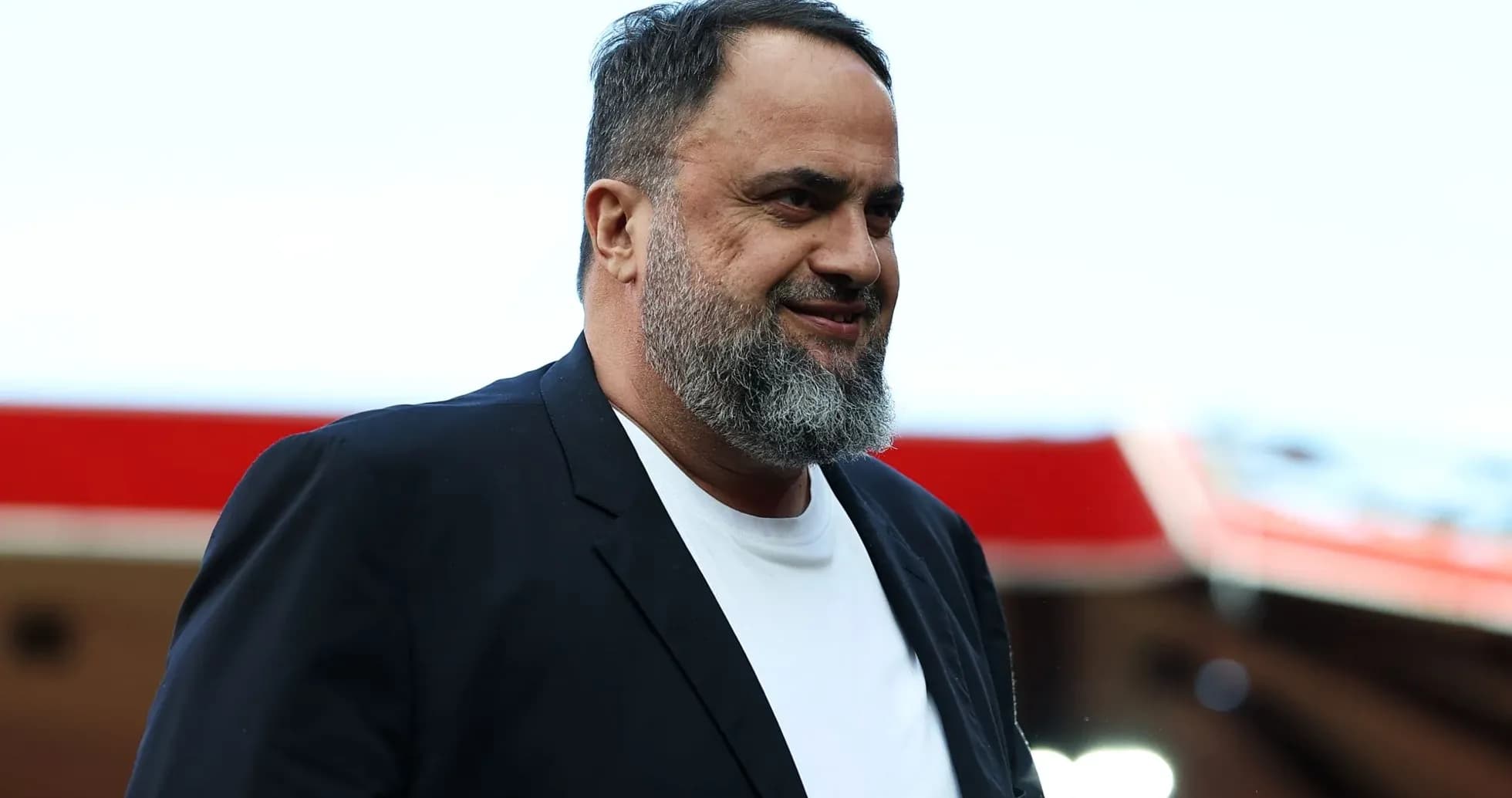 Man in a black blazer smiling outdoors Man in a black blazer smiling outdoors