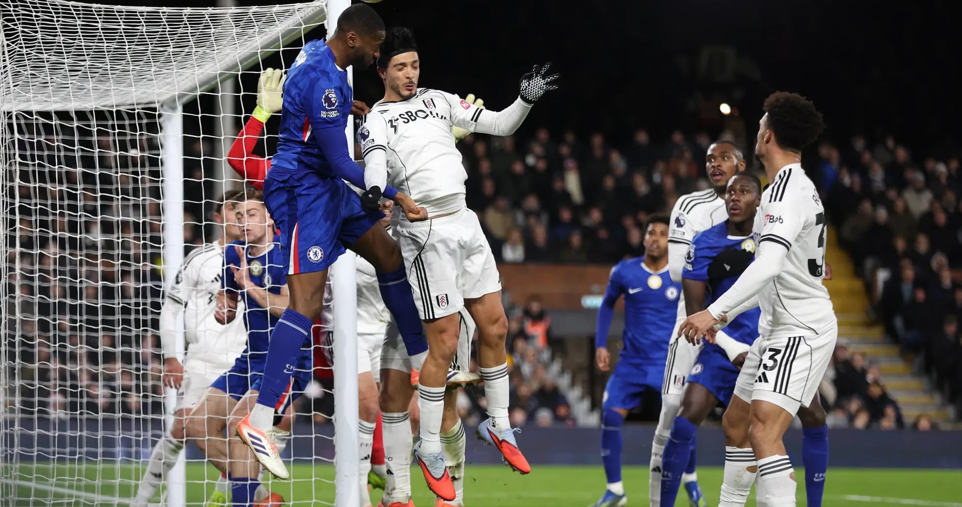 Chelsea player challenging Fulham goalkeeper during match Chelsea player challenging Fulham goalkeeper during match