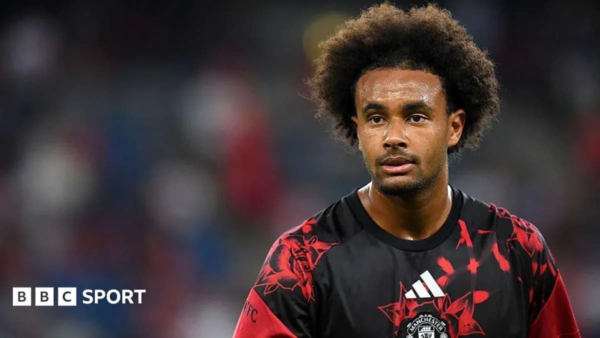Player in red and black jersey on the pitch Player in red and black jersey on the pitch