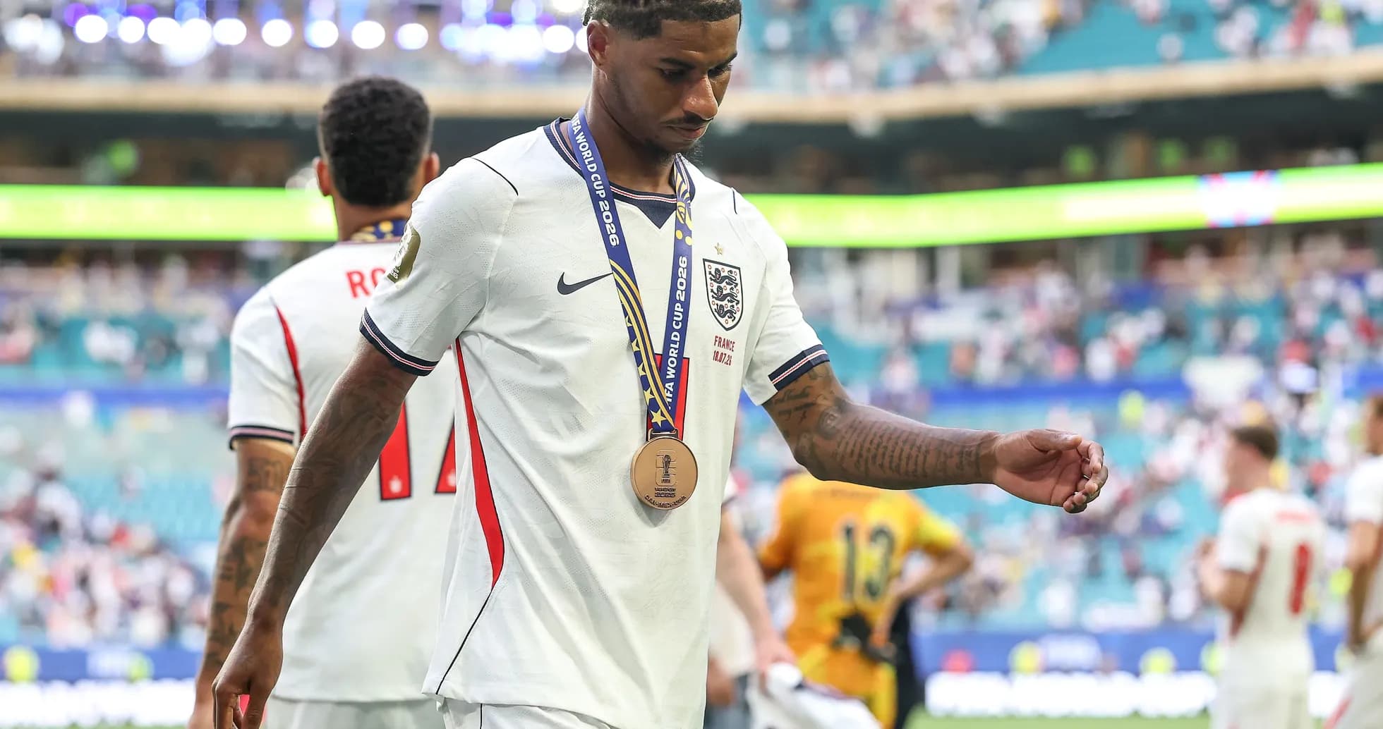 Player with bronze medal walking off the field Player with bronze medal walking off the field