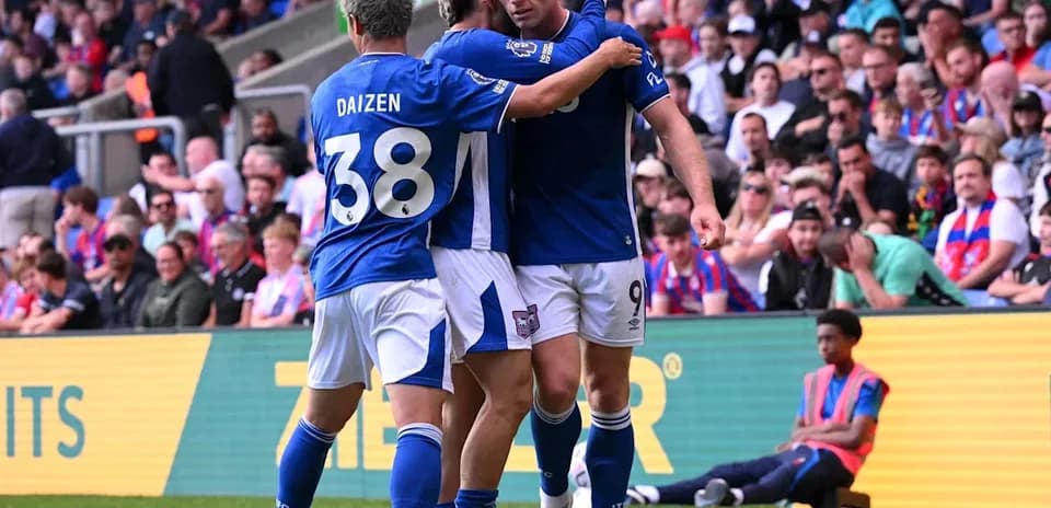 Players celebrating a goal on the pitch Players celebrating a goal on the pitch