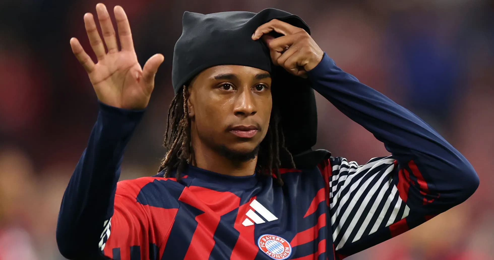 Player waving while adjusting headwear on field Player waving while adjusting headwear on field