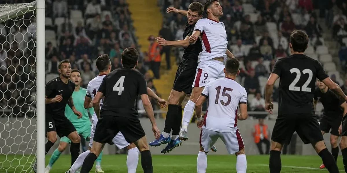 Players contesting a header in a football match Players contesting a header in a football match