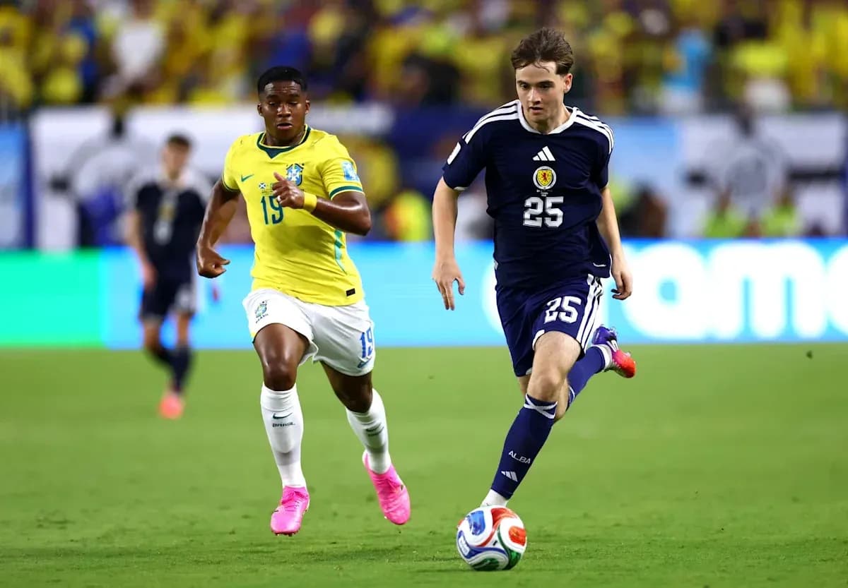 Player from Scotland dribbling ball, Brazilian defender chasing Player from Scotland dribbling ball, Brazilian defender chasing