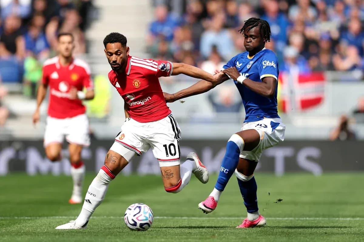 Player in red dribbling past opponent in blue Player in red dribbling past opponent in blue