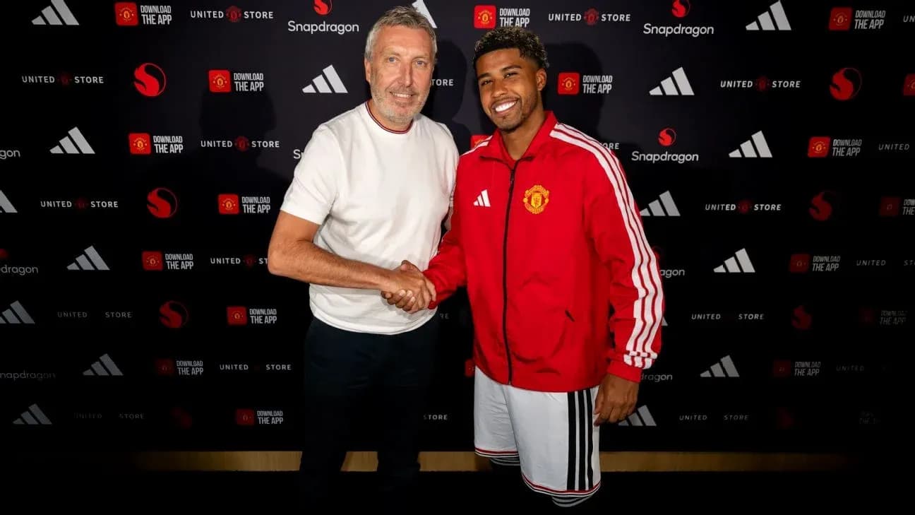 Two individuals shaking hands at Manchester United event Two individuals shaking hands at Manchester United event