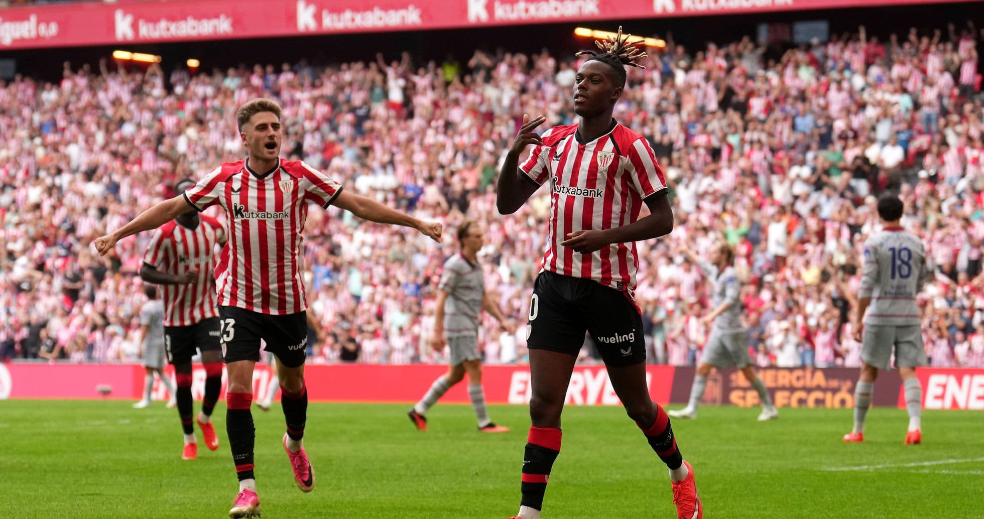 Player celebrating a goal with teammates in stadium Player celebrating a goal with teammates in stadium
