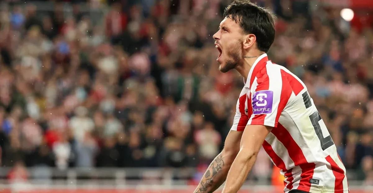 Player celebrating a goal with fans in background Player celebrating a goal with fans in background