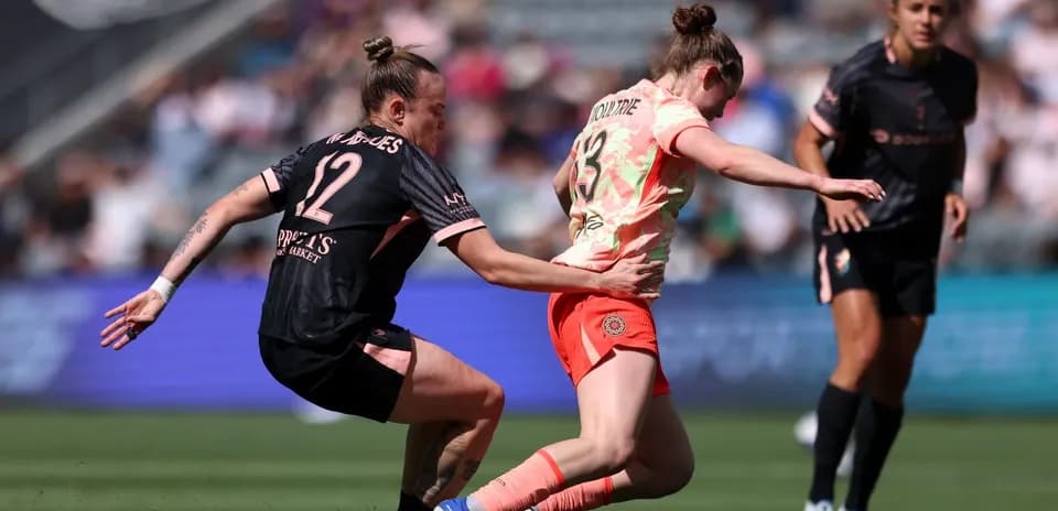 Player tackling opponent during NWSL match Player tackling opponent during NWSL match
