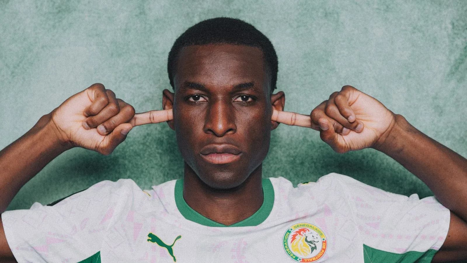 Player in Senegal jersey covering ears with hands Player in Senegal jersey covering ears with hands