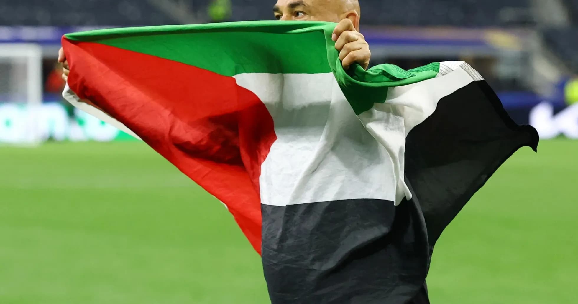 Person holding a flag on the field Person holding a flag on the field