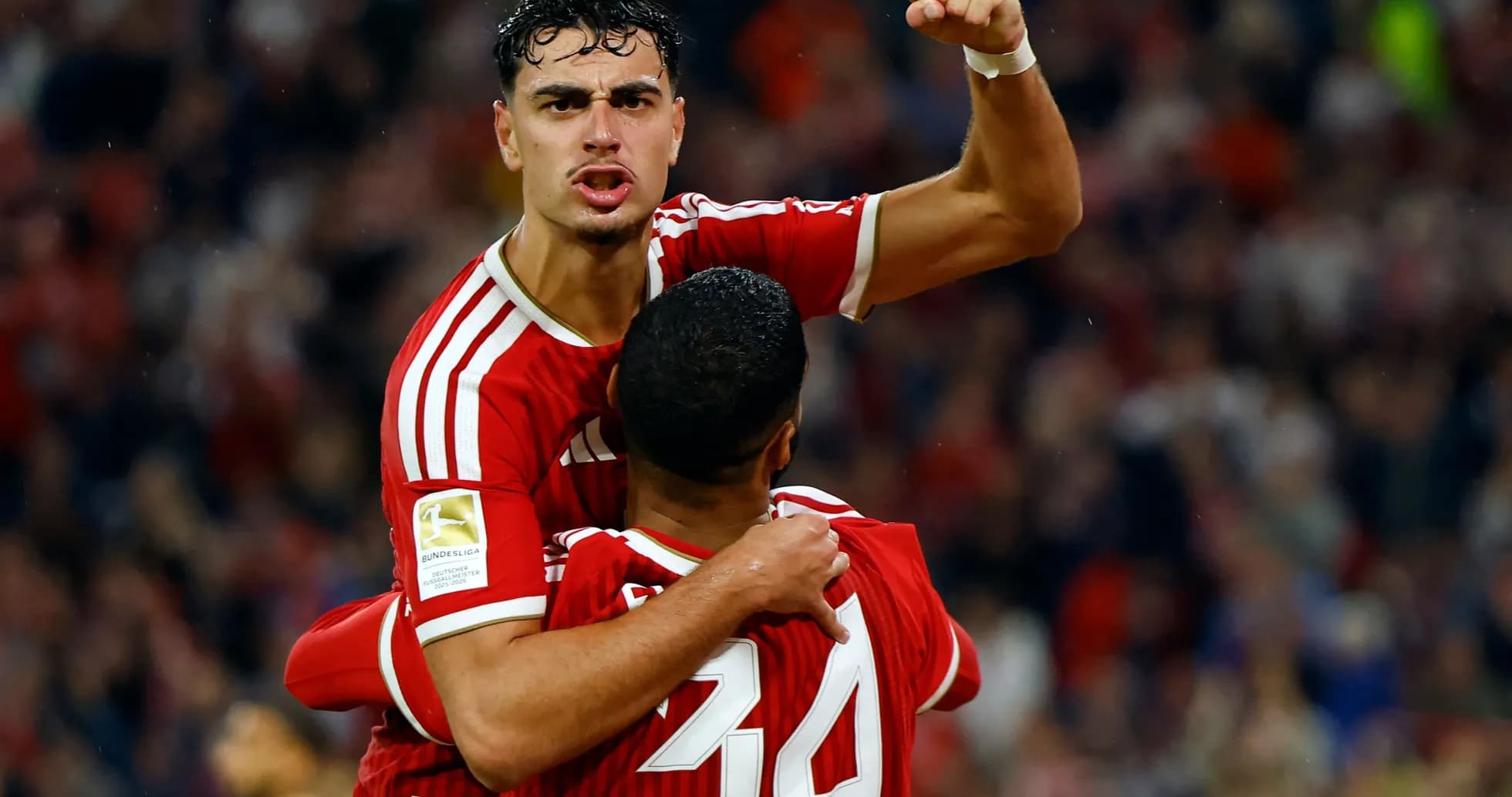 Two players celebrating a goal in red uniforms Two players celebrating a goal in red uniforms