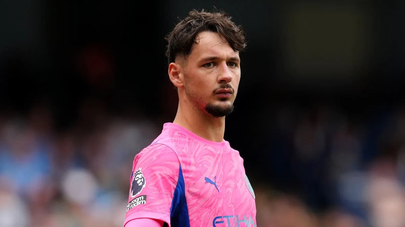 Goalkeeper in pink kit on the field Goalkeeper in pink kit on the field
