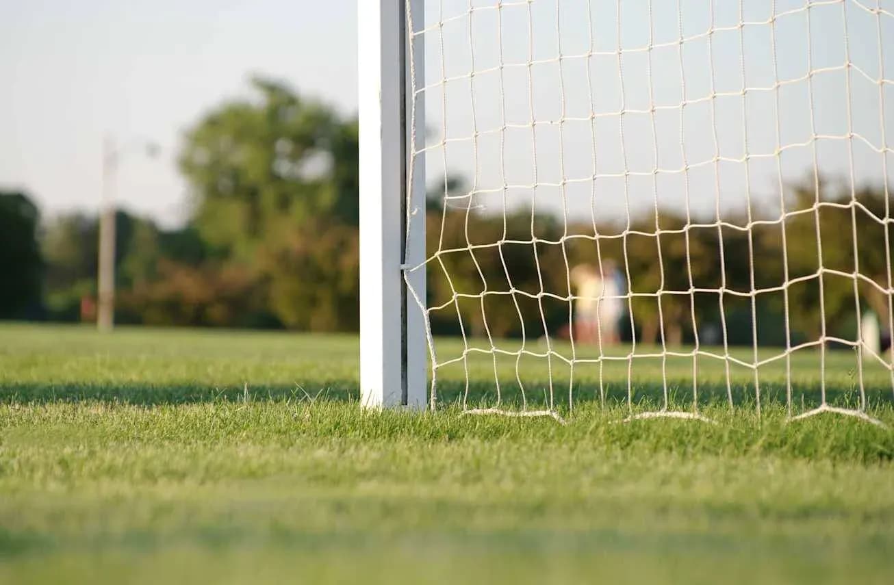 Close-up of soccer goal on grassy field Close-up of soccer goal on grassy field