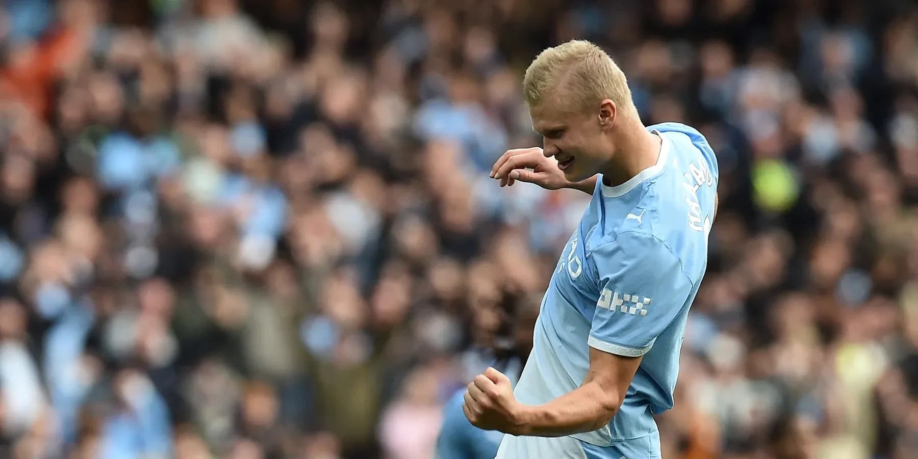 Player celebrating a goal with fans in background Player celebrating a goal with fans in background
