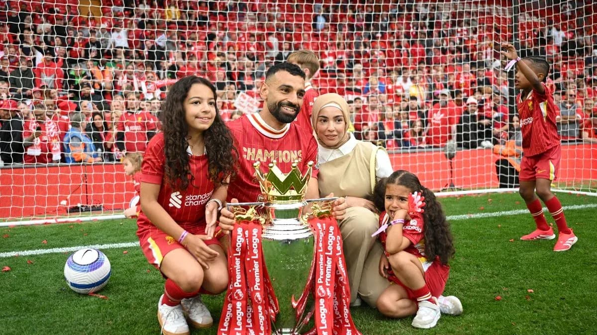 Player celebrating with family and trophy on field Player celebrating with family and trophy on field