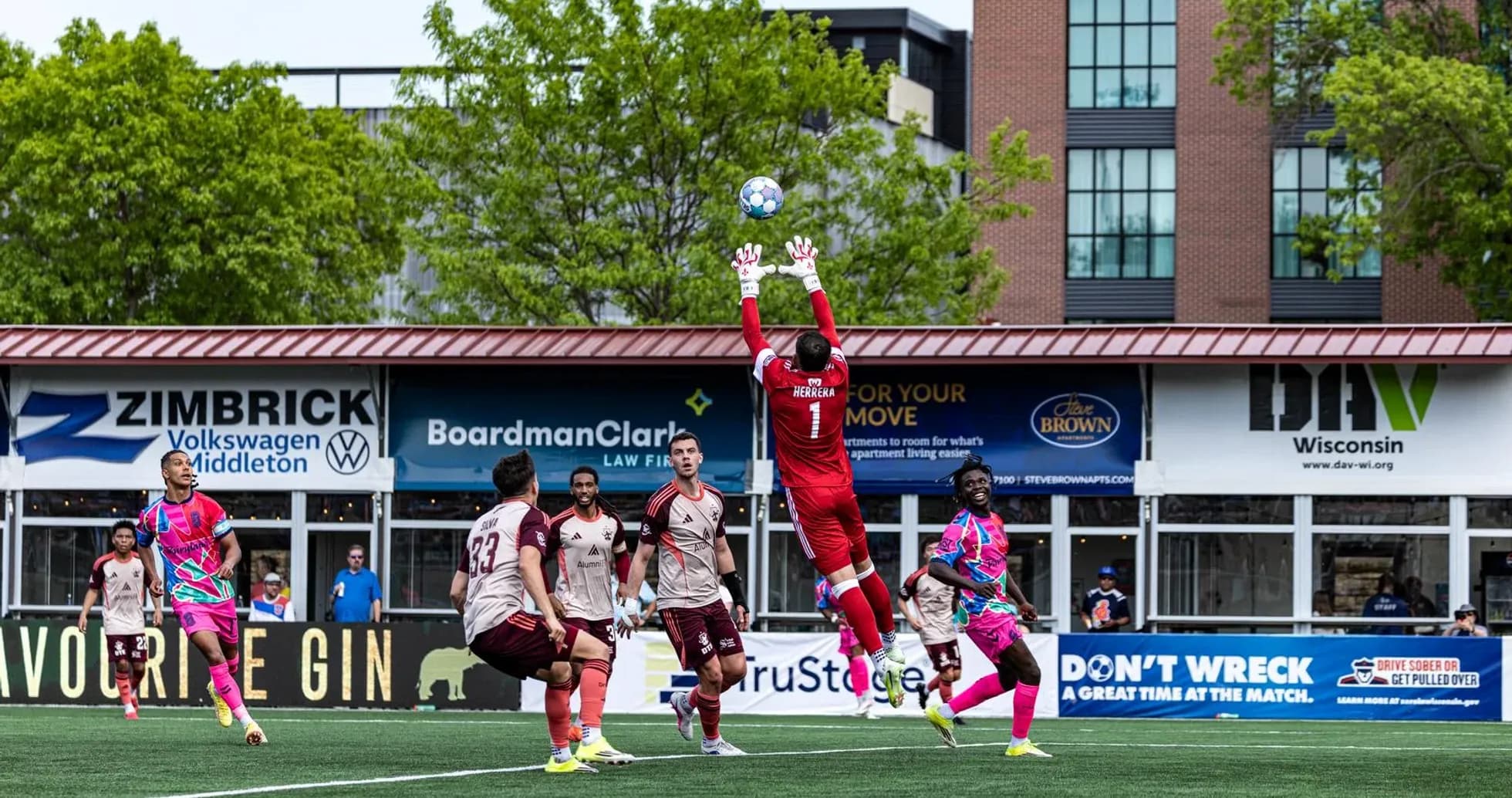 Goalkeeper jumping to catch the ball during match Goalkeeper jumping to catch the ball during match