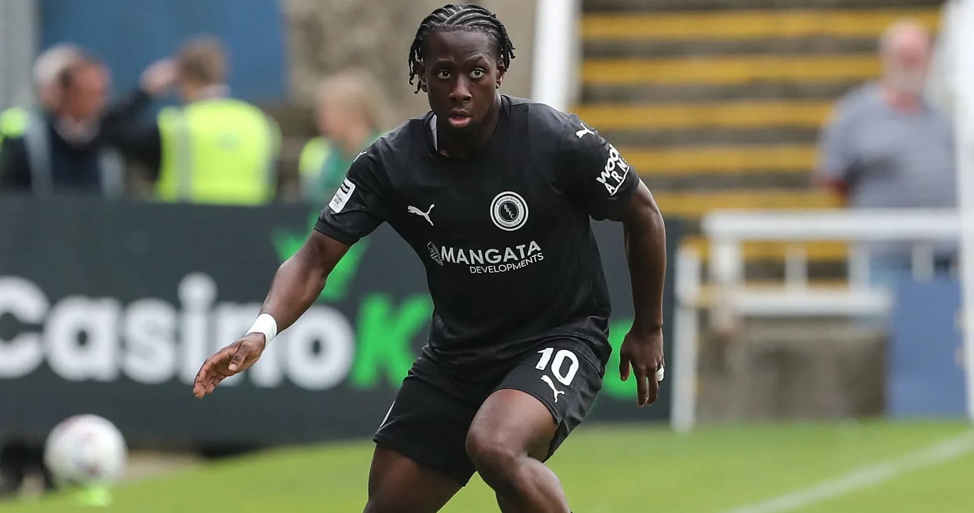 Player in black kit running with the ball Player in black kit running with the ball