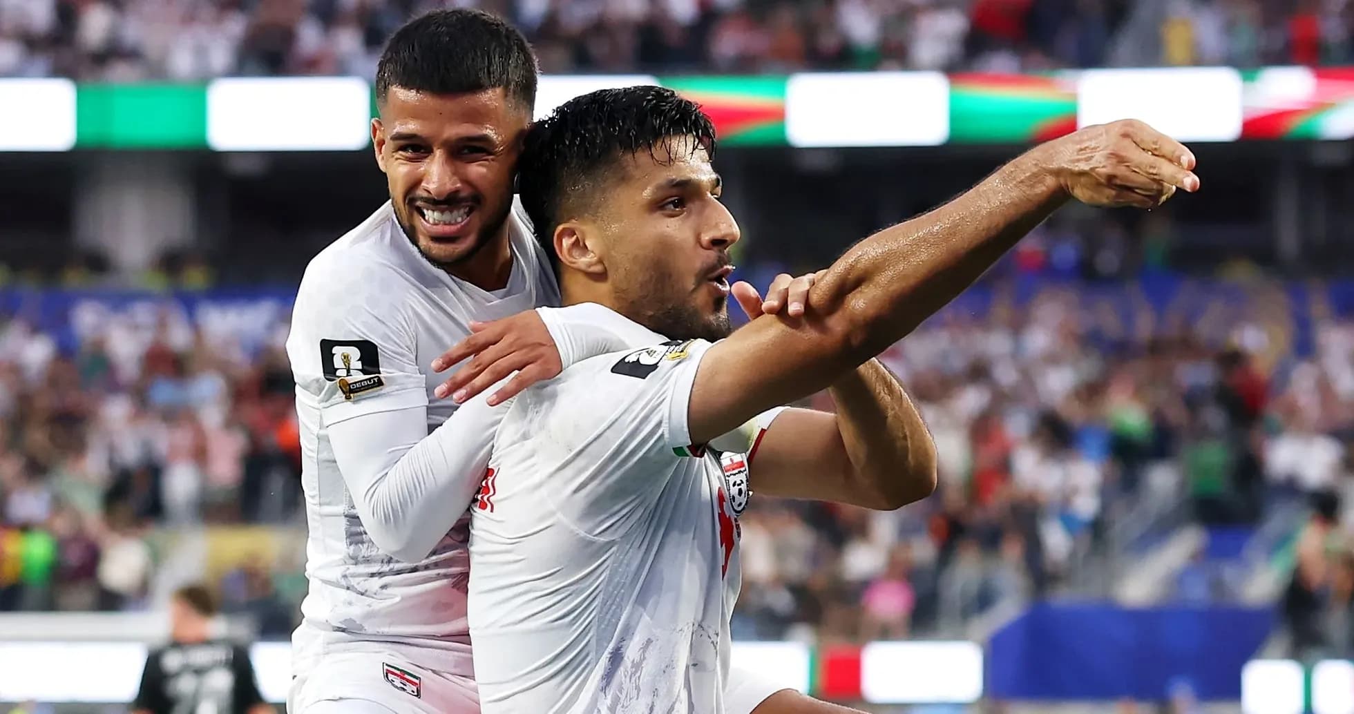 Two soccer players celebrating a goal together Two soccer players celebrating a goal together