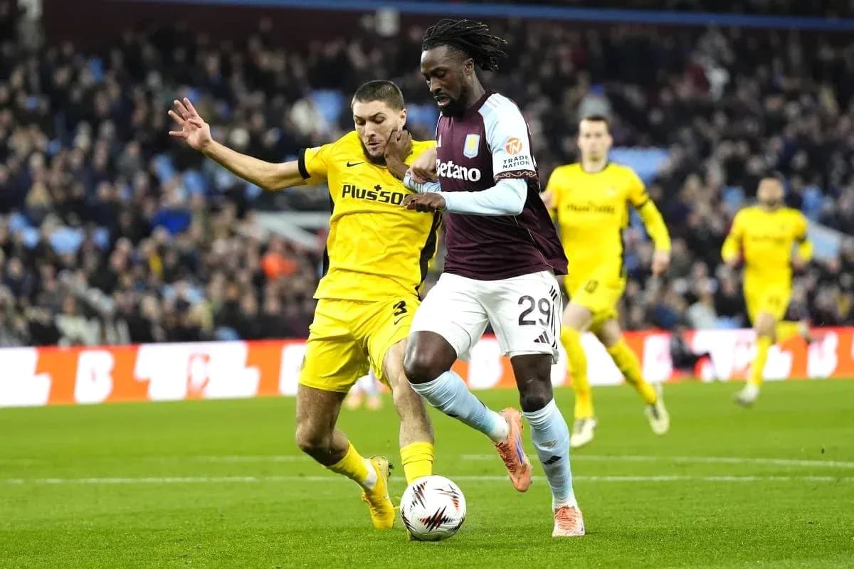 Player dribbling the ball while being challenged Player dribbling the ball while being challenged