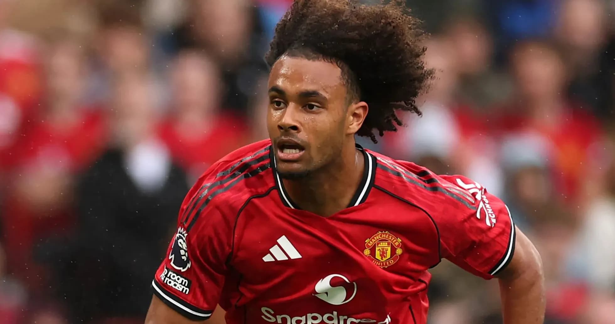 Player in red Manchester United kit running on pitch Player in red Manchester United kit running on pitch
