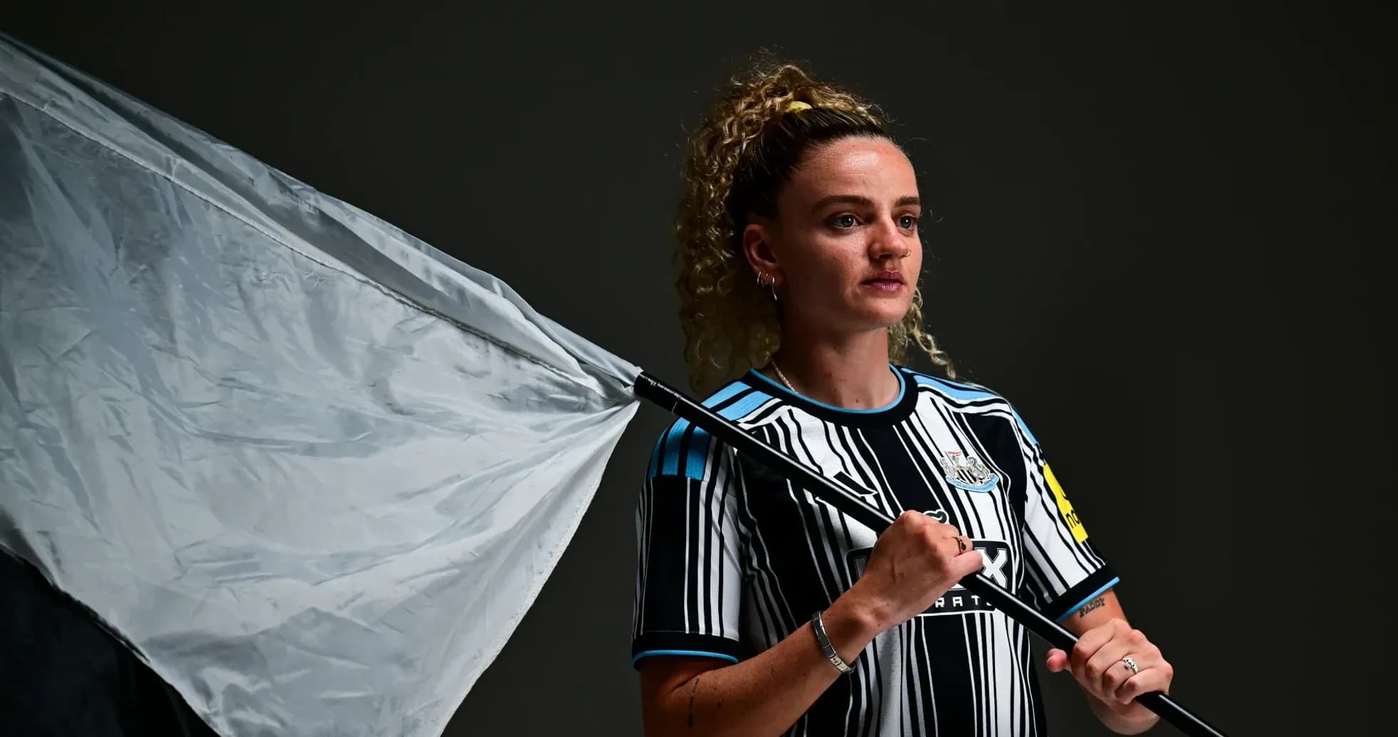 Player holding a flag in Newcastle jersey Player holding a flag in Newcastle jersey