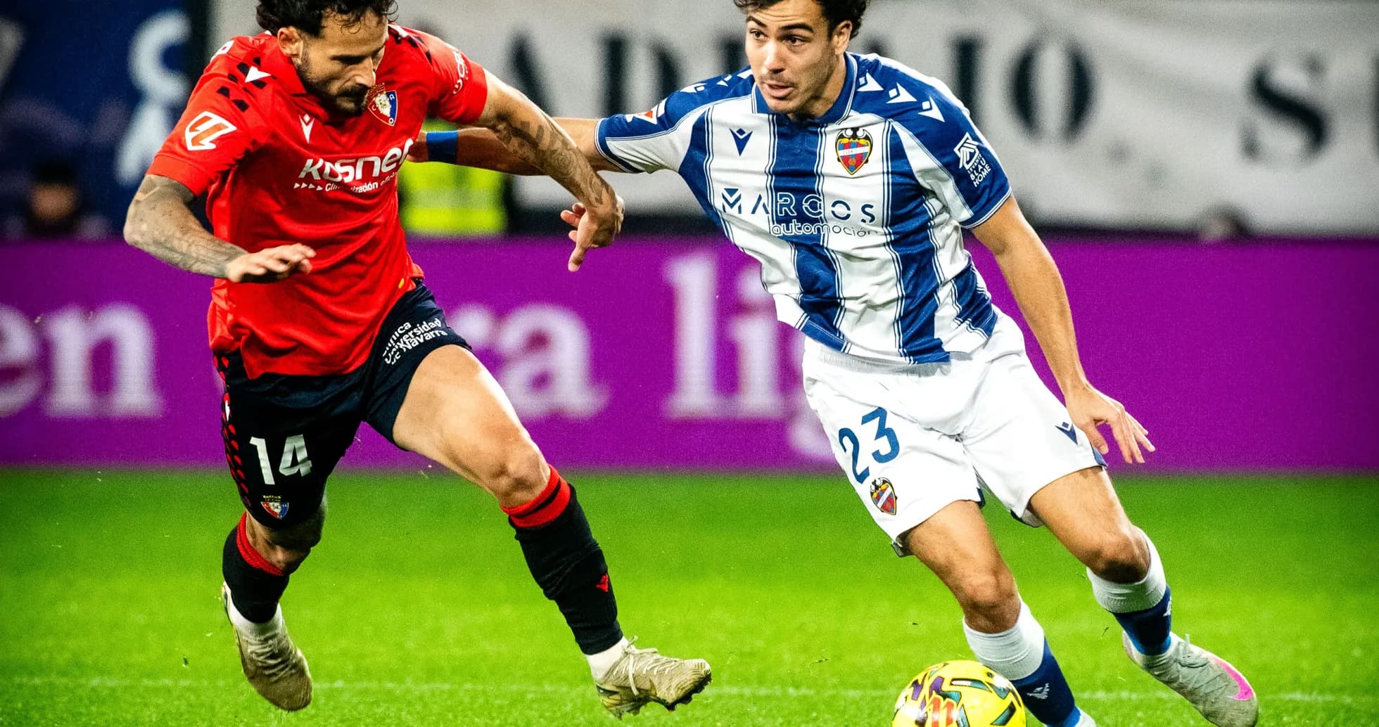 Levante player dribbling past Osasuna opponent Levante player dribbling past Osasuna opponent