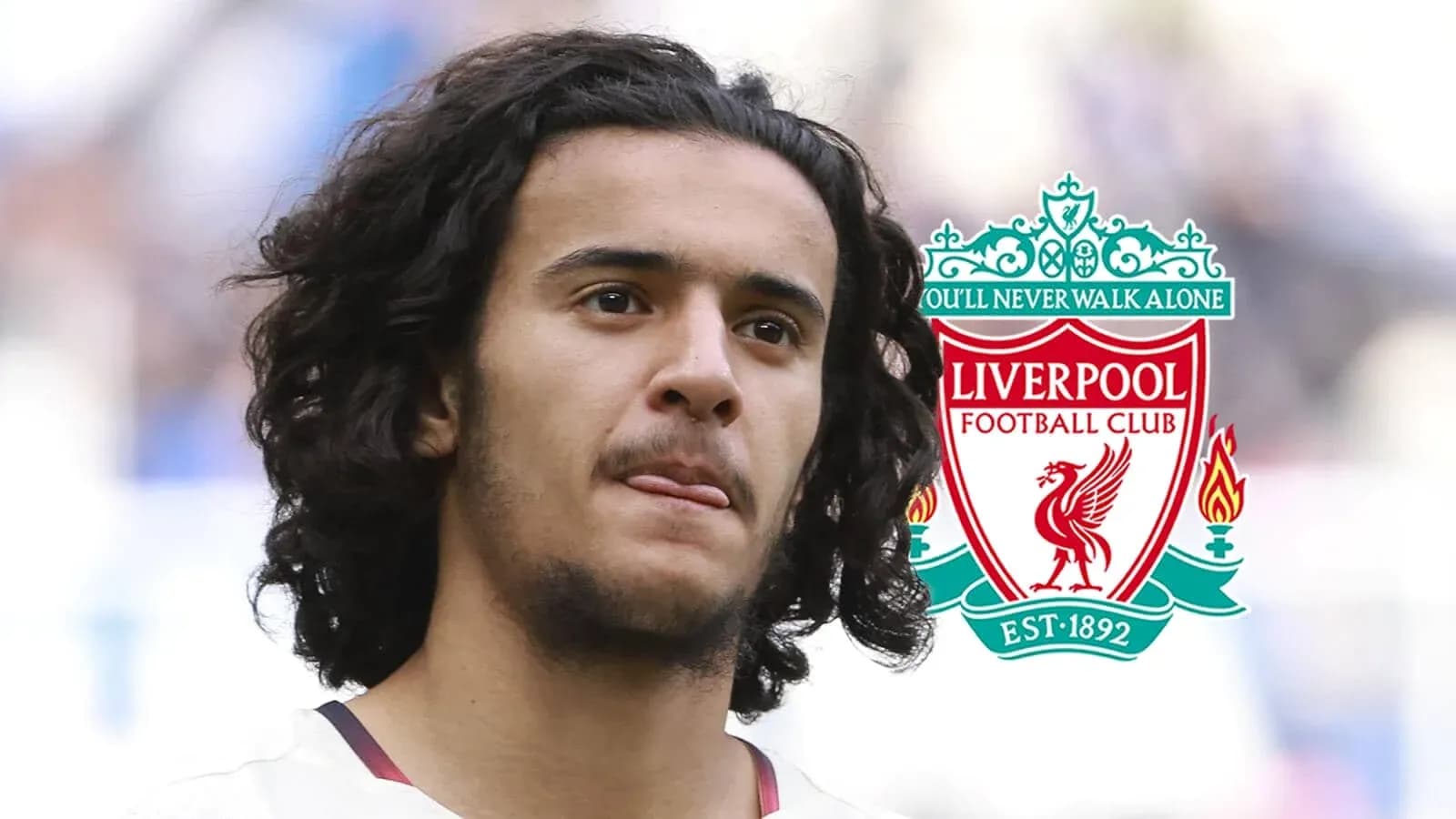 Player with long hair in front of Liverpool logo Player with long hair in front of Liverpool logo
