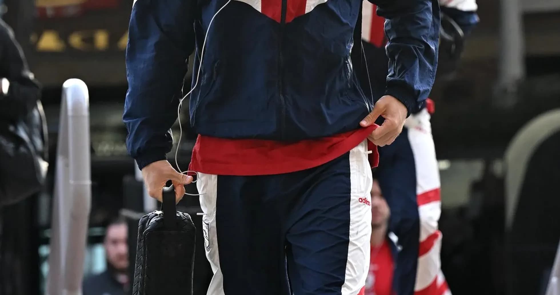 Player arriving in team tracksuit with bag Player arriving in team tracksuit with bag