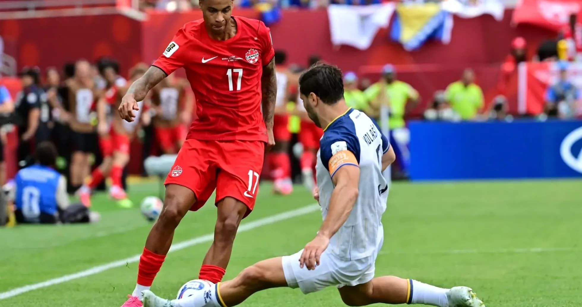 Canada player dribbling past Bosnia defender Canada player dribbling past Bosnia defender