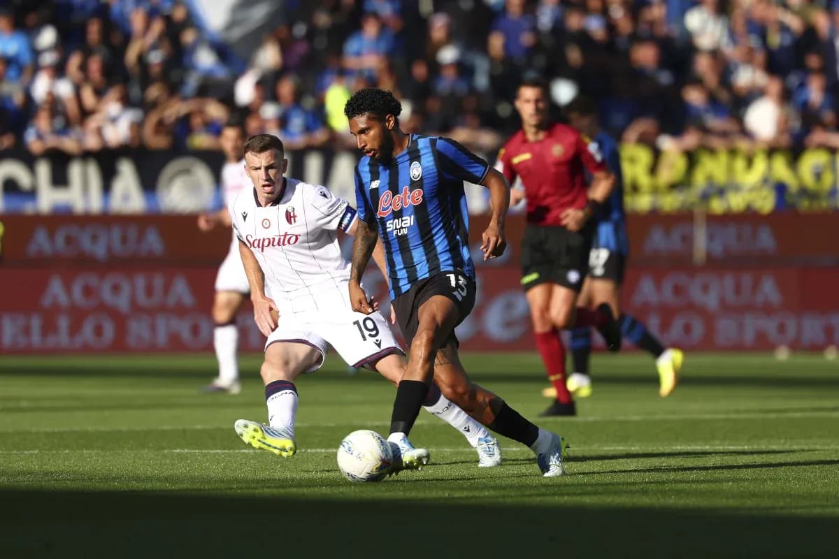 Atalanta player dribbling past Bologna defender Atalanta player dribbling past Bologna defender